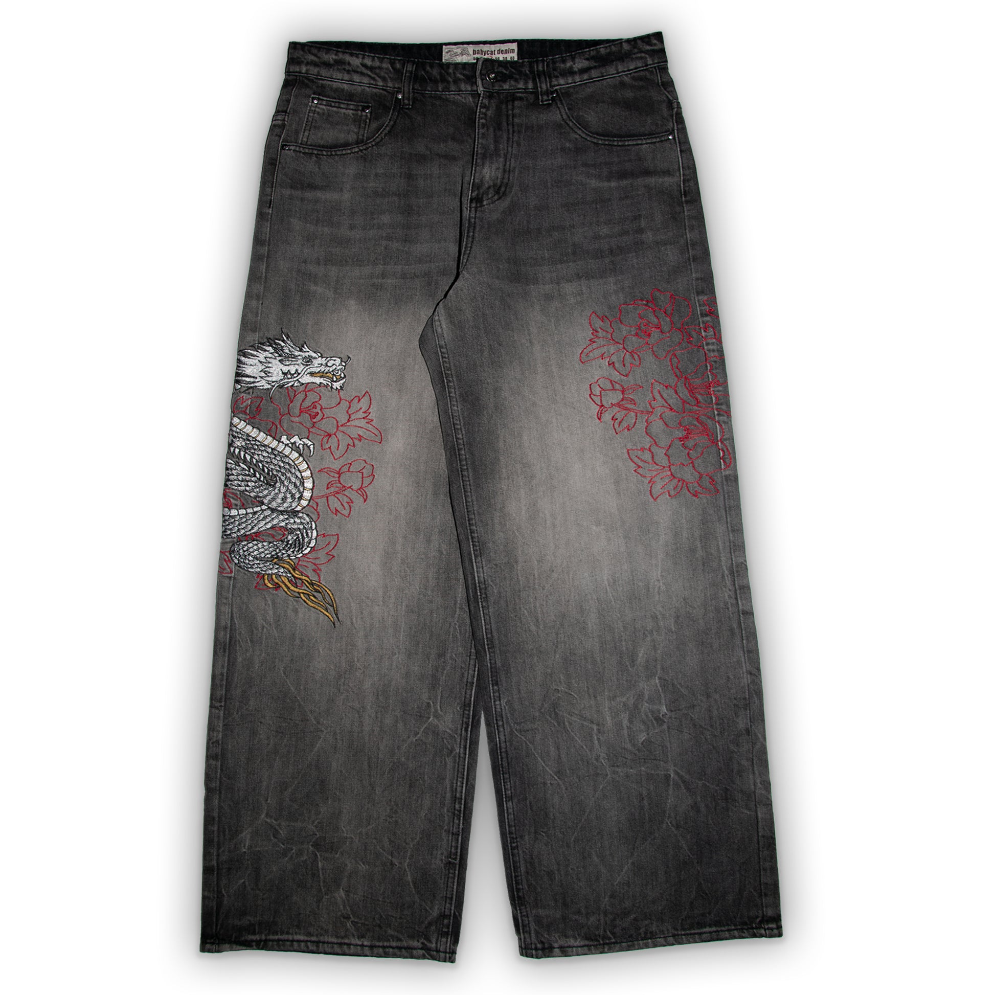 Black jeans with dragon and floral embroidery on a white background