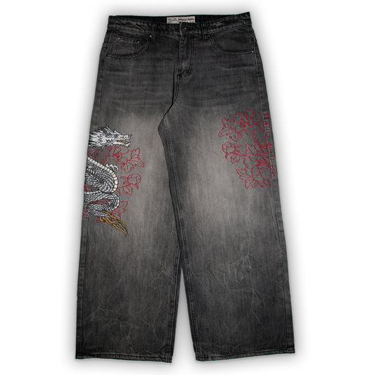 Black jeans with dragon and floral embroidery on a white background
