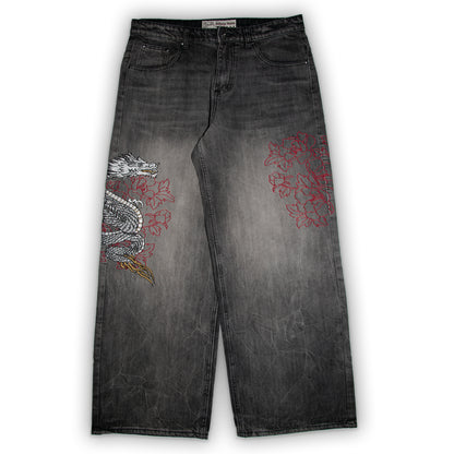 Black jeans with dragon and floral embroidery on a white background